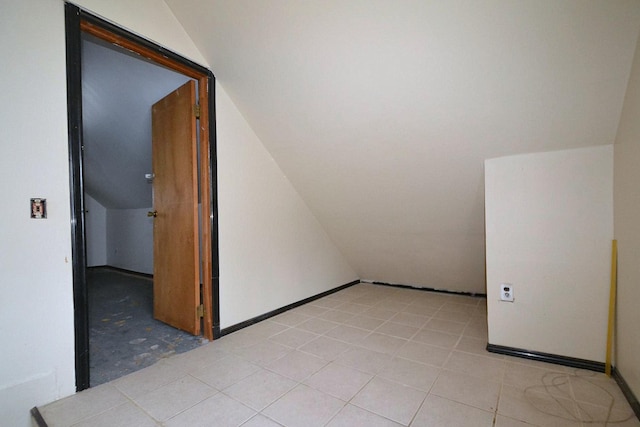 bonus room with lofted ceiling and baseboards