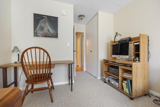 home office featuring light carpet, a textured ceiling, and baseboards