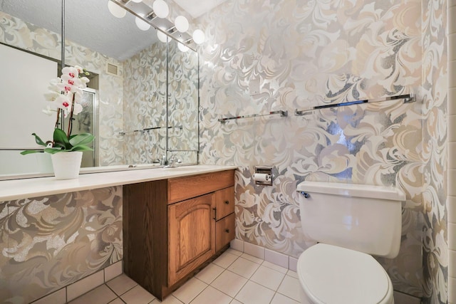 half bath with visible vents, tile patterned floors, toilet, and wallpapered walls