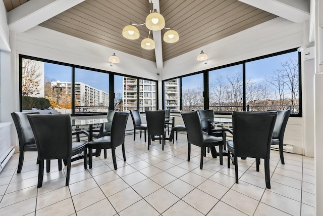 dining room featuring a wealth of natural light, vaulted ceiling, a notable chandelier, and light tile patterned flooring