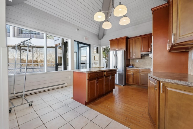 kitchen featuring a baseboard radiator, a center island, decorative light fixtures, freestanding refrigerator, and light countertops