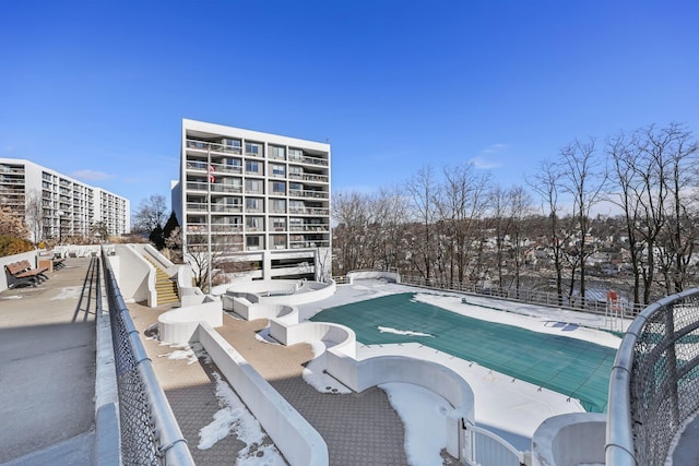 snow covered pool with a patio and a community pool