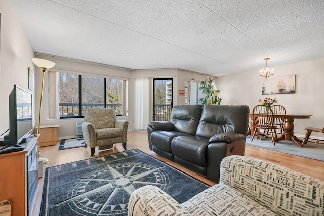 living room featuring a chandelier, a textured ceiling, wood finished floors, and a wealth of natural light