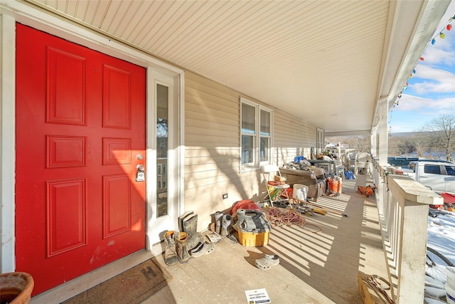 snow covered property entrance with covered porch