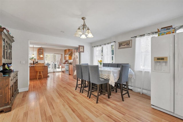 dining area featuring light wood-type flooring and a chandelier