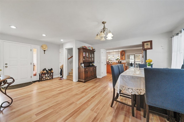 dining area with a notable chandelier and light hardwood / wood-style floors