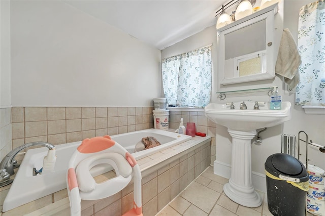 bathroom with tile patterned flooring, tiled tub, and lofted ceiling