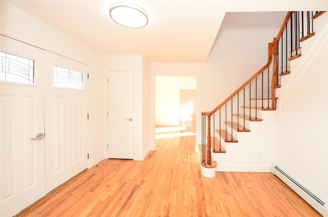 entryway featuring baseboard heating and light hardwood / wood-style floors