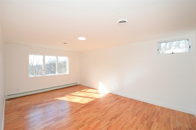 spare room with light wood-type flooring, plenty of natural light, and baseboard heating