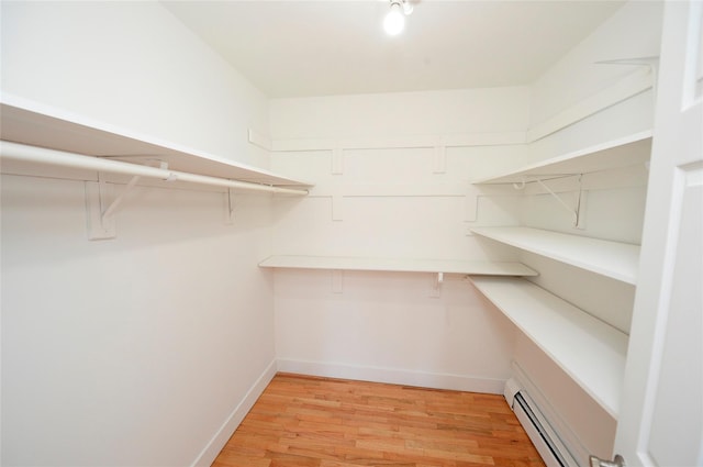 walk in closet featuring light hardwood / wood-style flooring and a baseboard heating unit