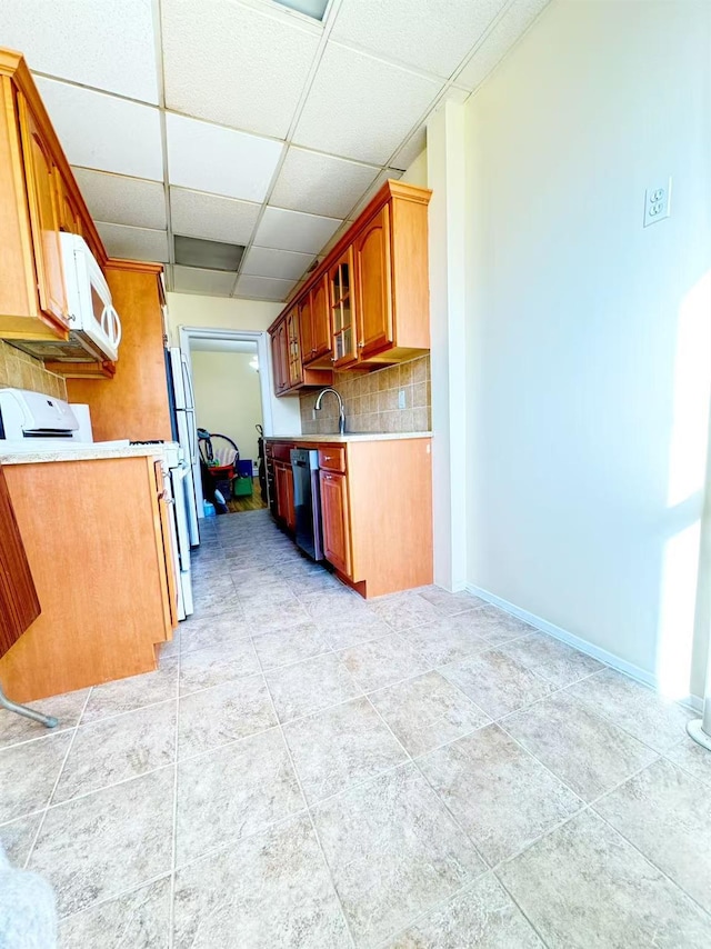 kitchen with sink, range, tasteful backsplash, a drop ceiling, and stainless steel dishwasher