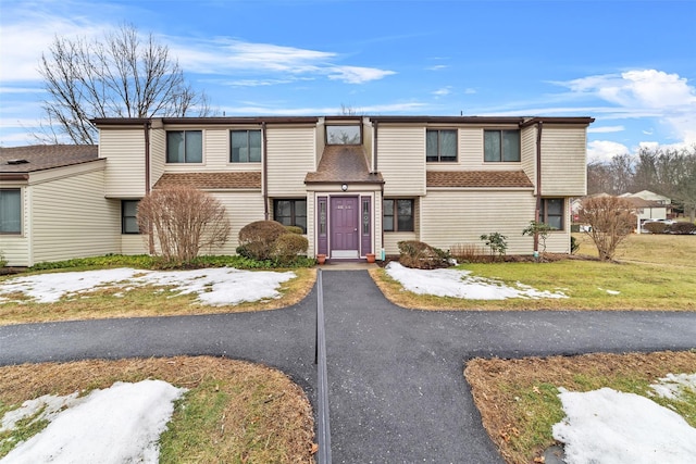 townhome / multi-family property featuring a front lawn