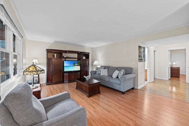 living area with light wood-style flooring and baseboards