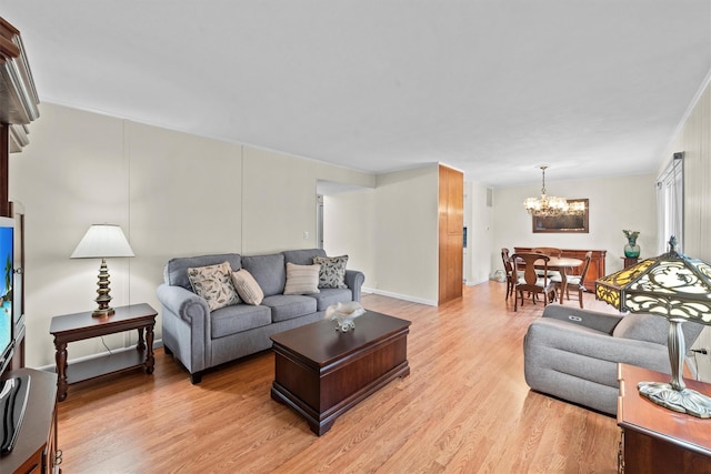 living room featuring a notable chandelier and light wood finished floors