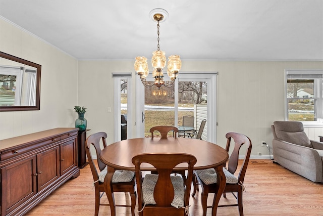 dining room featuring a chandelier, ornamental molding, baseboards, and light wood-style floors