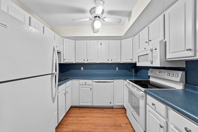 kitchen with white appliances, light wood finished floors, white cabinets, a ceiling fan, and dark countertops