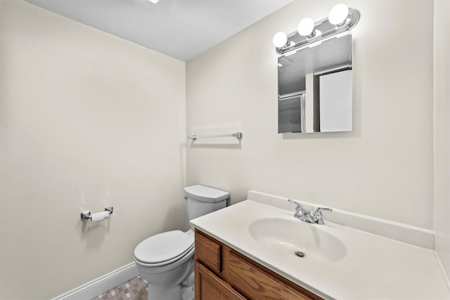 bathroom with vanity, toilet, and baseboards