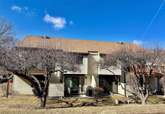 rear view of house featuring a shingled roof