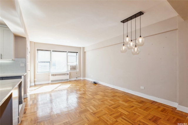 unfurnished dining area featuring radiator heating unit and light parquet floors