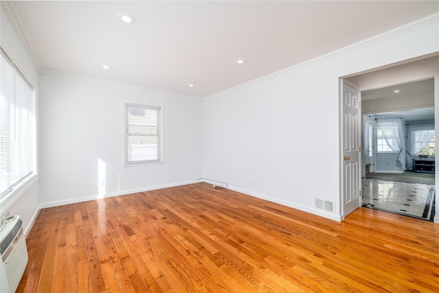 unfurnished room with light wood finished floors, recessed lighting, visible vents, ornamental molding, and baseboards