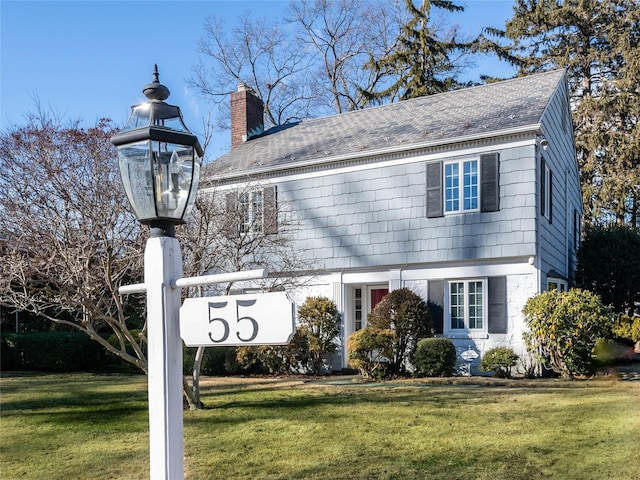 exterior space featuring a chimney and a front lawn