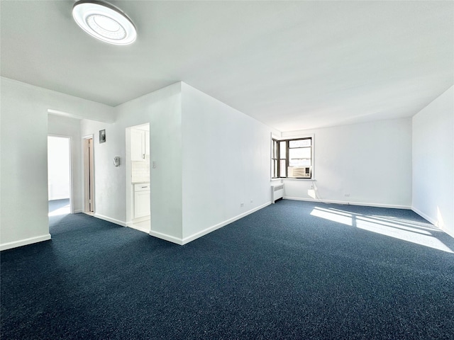 carpeted empty room featuring cooling unit and radiator heating unit