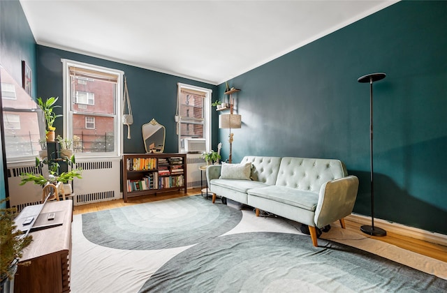 sitting room with cooling unit, radiator, and hardwood / wood-style floors