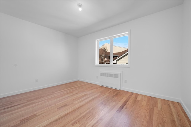 empty room featuring radiator and light hardwood / wood-style floors