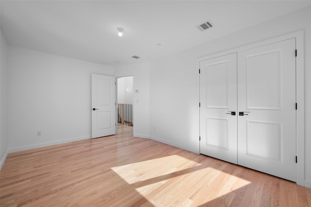 unfurnished bedroom featuring light hardwood / wood-style floors and a closet