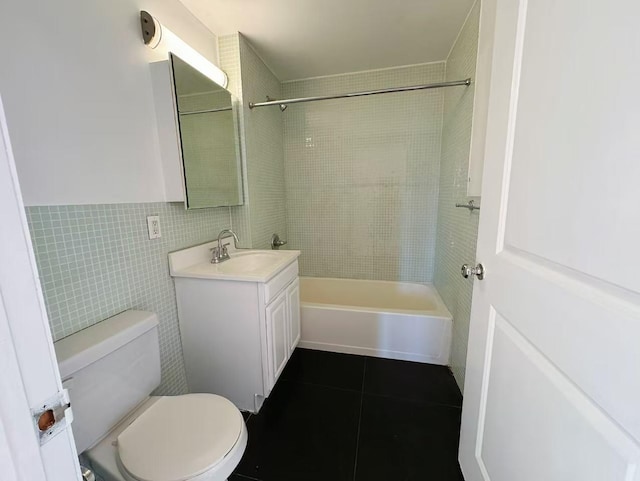 bathroom with shower / tub combination, toilet, tile walls, vanity, and tile patterned floors