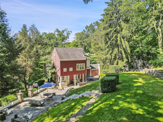 back of property featuring a patio area and a lawn