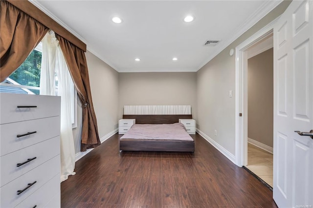 unfurnished bedroom featuring dark wood-style flooring, visible vents, and crown molding