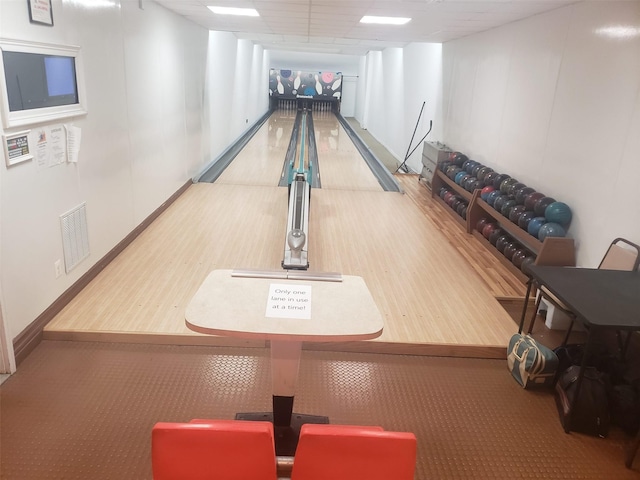 recreation room with a paneled ceiling and bowling