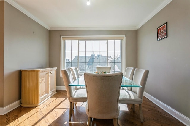 dining area with light wood-style floors, baseboards, and crown molding