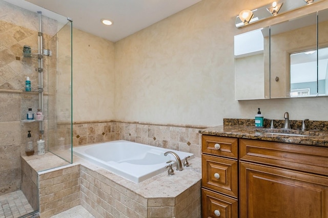 bathroom featuring a garden tub, a shower stall, and vanity