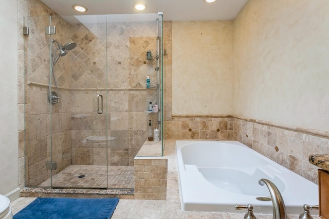 full bath featuring recessed lighting, a garden tub, and a shower stall