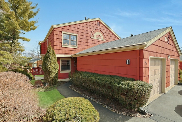 view of front of house featuring a garage and roof with shingles