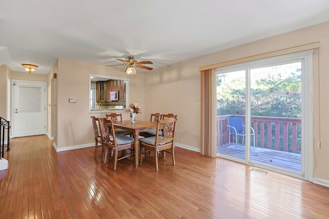 dining area with light wood finished floors, visible vents, a ceiling fan, and baseboards