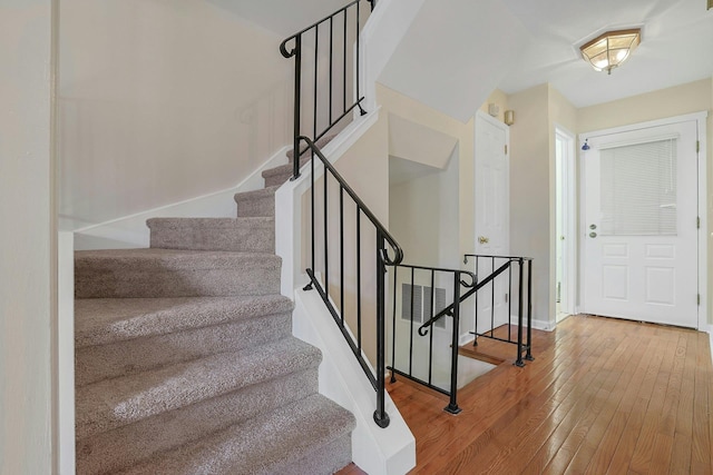 stairs with baseboards and wood-type flooring