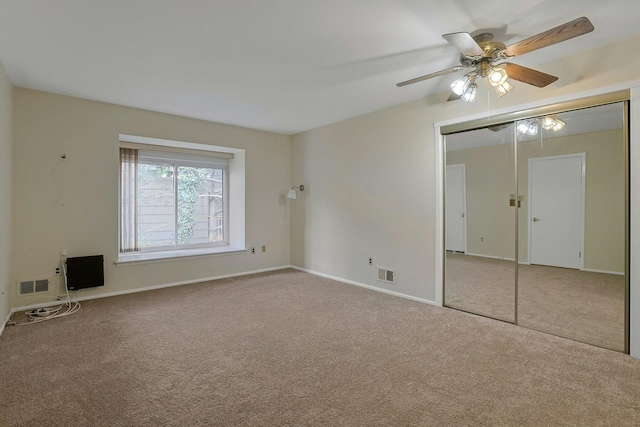 unfurnished bedroom featuring a ceiling fan, carpet, visible vents, and a closet