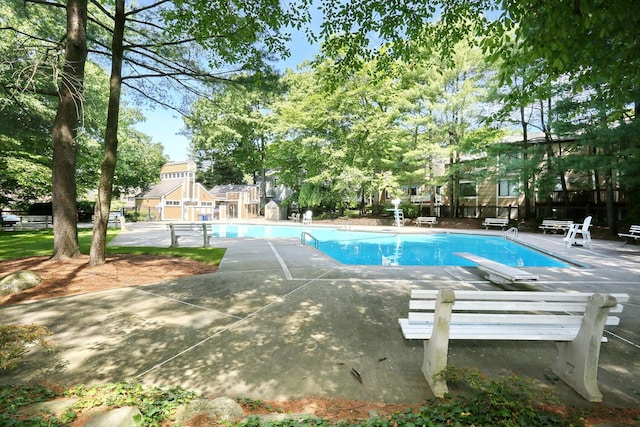 community pool with a patio area and fence