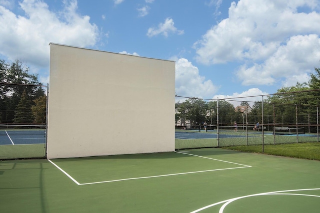 view of tennis court featuring fence