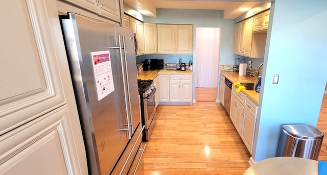 kitchen with sink, light wood-type flooring, and stainless steel appliances