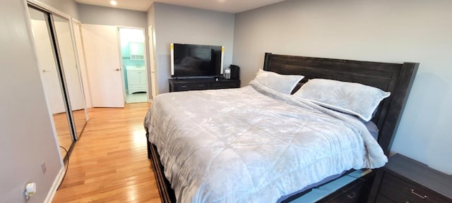 bedroom featuring light hardwood / wood-style floors and connected bathroom