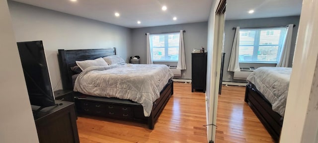 bedroom featuring light hardwood / wood-style flooring and a baseboard heating unit