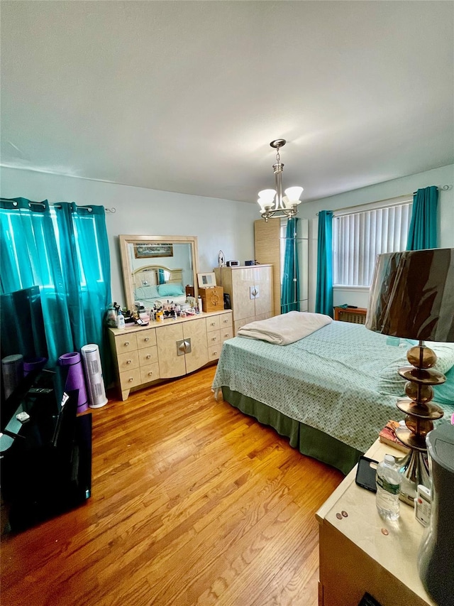 bedroom featuring light wood-type flooring and a chandelier