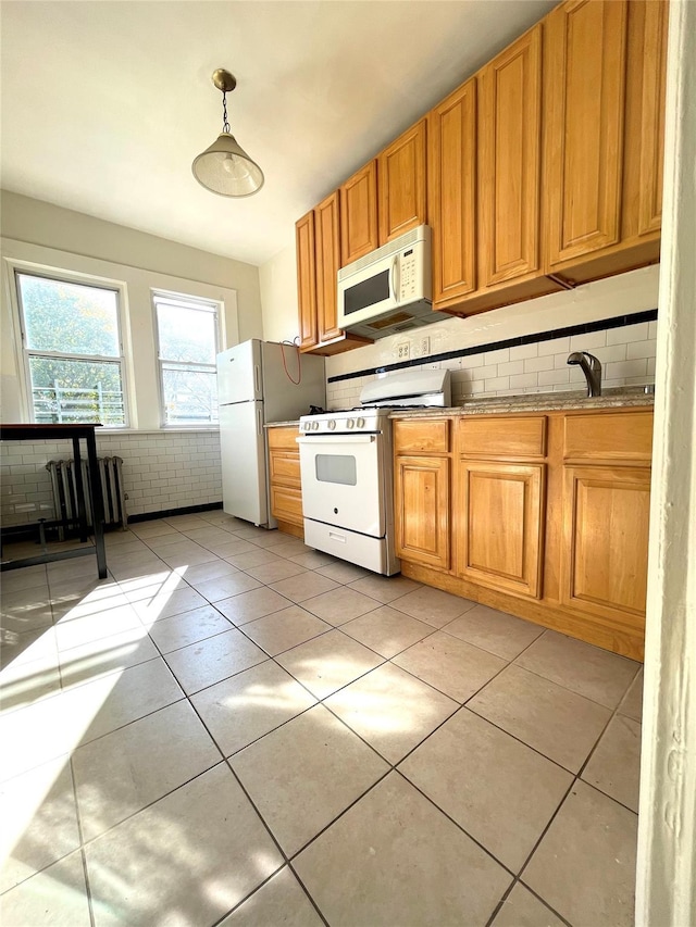 kitchen featuring white appliances, light tile patterned floors, sink, backsplash, and pendant lighting