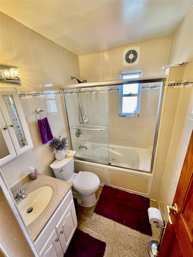 full bathroom featuring enclosed tub / shower combo, toilet, tile walls, tasteful backsplash, and vanity