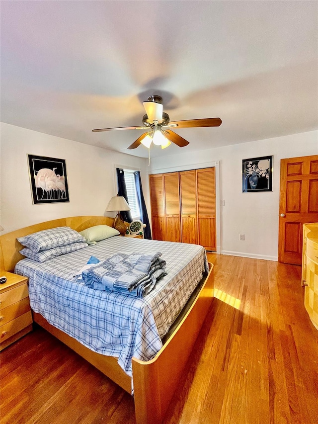 bedroom with hardwood / wood-style flooring, ceiling fan, and a closet