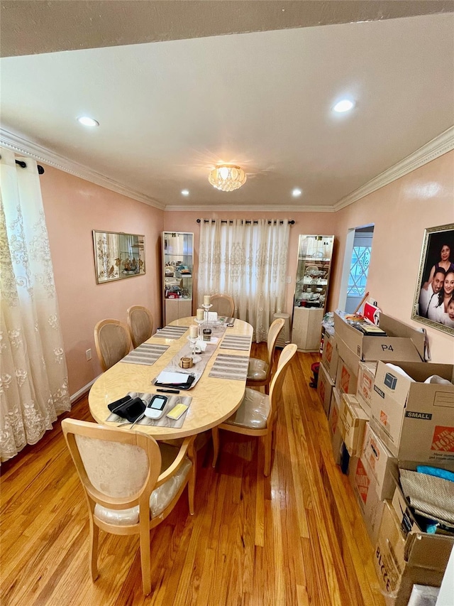 dining area with light hardwood / wood-style floors and ornamental molding